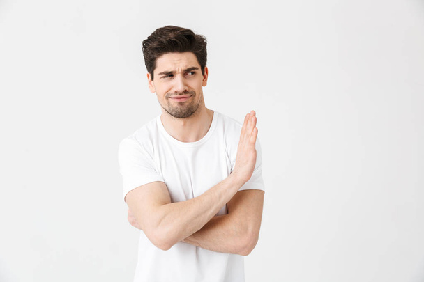 Displeased young man posing isolated over white wall background make stop gesture. - Fotografie, Obrázek