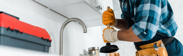 panoramic shot of repairman holding plunger in kitchen  - Photo, Image