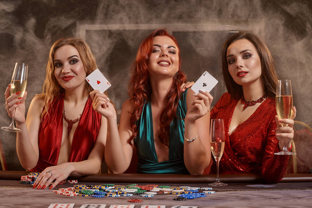 Grupo de mujeres jóvenes y adineradas están jugando al póquer en un casino. - Foto, Imagen