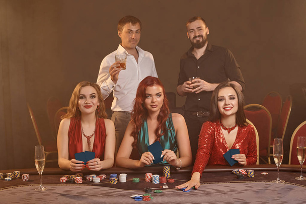Grupo de jóvenes amigos ricos están jugando al póquer en un casino
. - Foto, imagen
