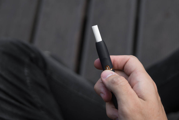 Elektronikus cigaretta férfi kezében. Egy férfi dohányzik elektronikus cigaretta. - Fotó, kép
