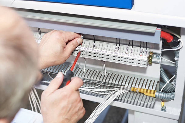 El electricista realiza la instalación y configuración de equipos de alta tensión
. - Foto, imagen
