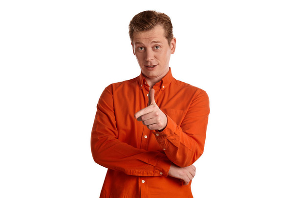 Close-up portrait of a young good-looking ginger male in a stylish orange shirt gesticulating and looking at the camera while posing isolated on white studio background. Human facial expressions. Sincere emotions concept. Copy space. - Foto, afbeelding