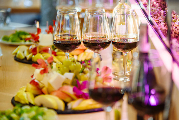 Стіл "шведський стіл" з келихами червоного вина
 - Фото, зображення