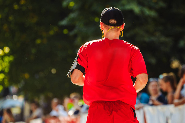 Марафонский бегун в красной футболке с держателем для телефона
 - Фото, изображение