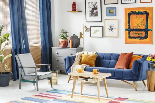 Bright and cozy living room interior with blue drapes, a sofa wi - Fotó, kép