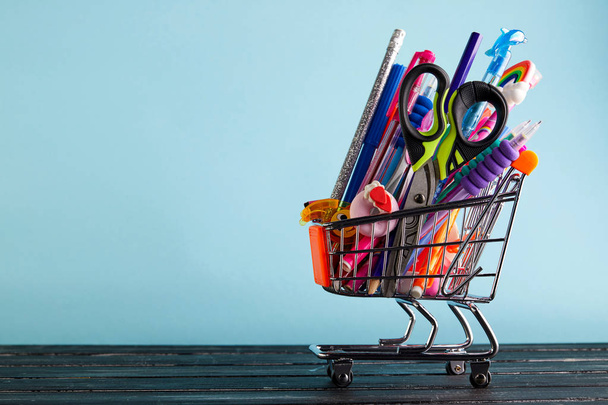 Banner of Shopping cart with school supply on a blue background with copy space. Back to school - Foto, Bild