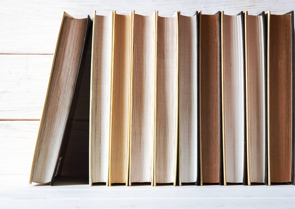 A sárga oldalú régi könyvek fehér, fából készült polcra állnak - Fotó, kép