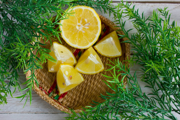 Cunei di limone in un cesto di vimini con foglie verdi
 - Foto, immagini