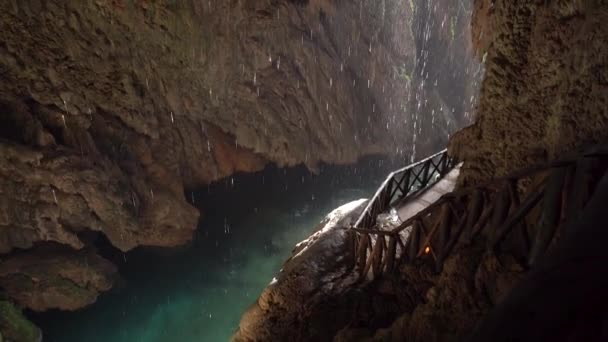 Kapky kapající do vody v malé jeskyni. Vodopád v tropické deštné lesní krajině. - Záběry, video