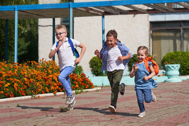a group of school children running out of school - Фото, изображение