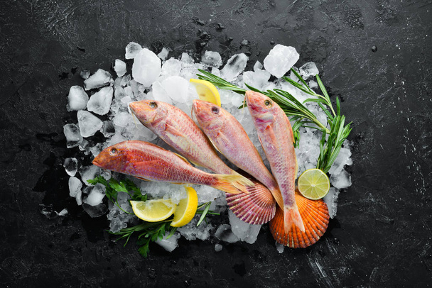 red mullet fish. Sea fish. Seafood on black background. Top view. Free copy space. - Photo, image