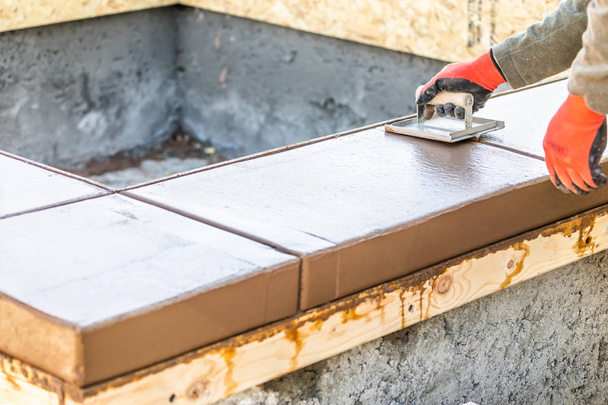 Строитель с помощью паха на мокрой цементной формовки справляется с новым бассейном - Фото, изображение