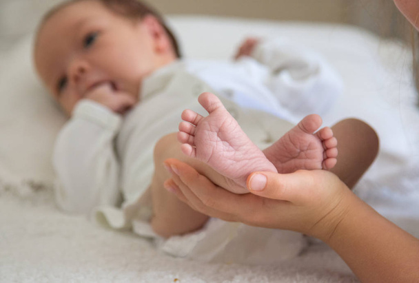 Hands hold the foot of a newborn baby - Valokuva, kuva