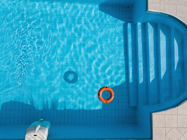 Boia salva-vidas laranja em uma piscina no verão
 - Foto, Imagem