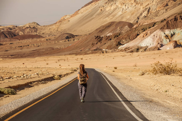 hitchhiker woman walking on a road in USA - Fotoğraf, Görsel