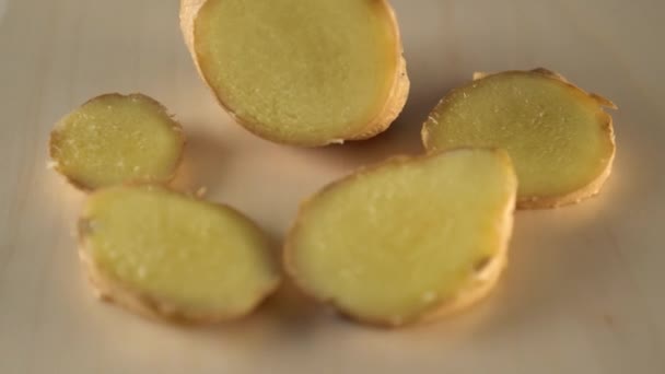Juicy ripe slices of ginger root spin on a wooden surface. Making Ginger Sauce and Tea - Záběry, video