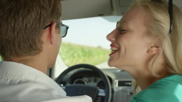 Movimiento lento, CERRAR: Alegre chica caucásica con labios rojos vibrantes besa a su novio en la mejilla durante su viaje romántico por la carretera a través de la pintoresca campiña. Adorable pareja enamorada
 - Imágenes, Vídeo