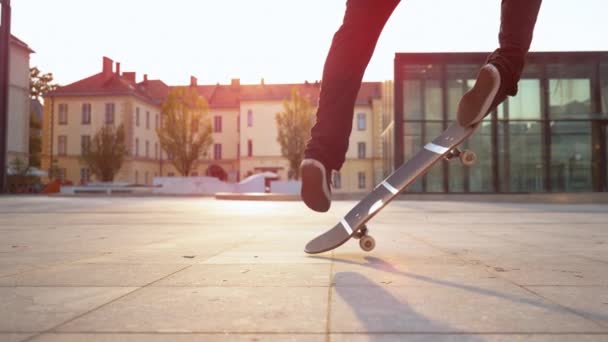 SLOW MOTION, FLOSE UP, LENS FLARE: O patinador irreconhecível faz um fakie em uma praça da cidade ao pôr do sol. Jovem skatista pousa um truque difícil enquanto patina no parque de skate urbano na noite ensolarada
 - Filmagem, Vídeo