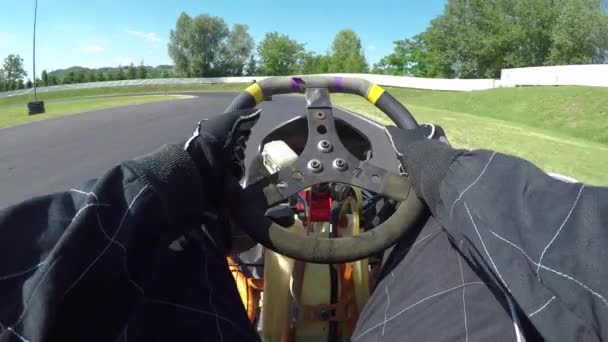 POV, LENS FLARE: Having fun racing a go kart along a bumpy asphalt racetrack on a sunny day. Cool shot of arms and legs driving a fast go-cart around the raceway during a cool time trial competition. - Footage, Video