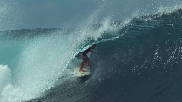 MOCIÓN LENTA, CERRAR: Joven surfista disfrutando del increíble verano surfeando una gran ola de esmeralda. Ajuste turístico masculino coge una gran ola de barril corriendo hacia las playas de Tahití. Deportes acuáticos extremos
. - Metraje, vídeo
