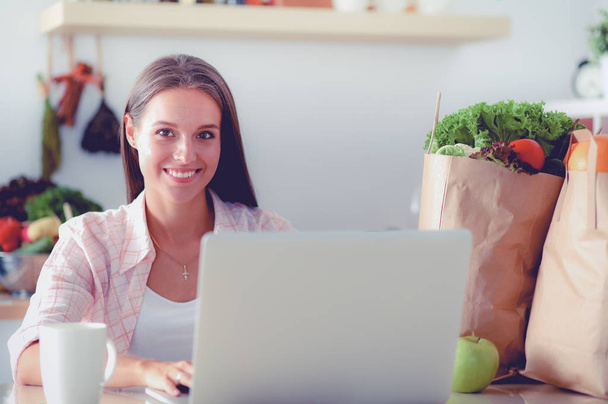 Smiling woman online shopping using tablet and credit card in kitchen . Smiling woman - Φωτογραφία, εικόνα