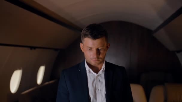Entrepreneur raising his look to the camera in business jet. - Materiał filmowy, wideo