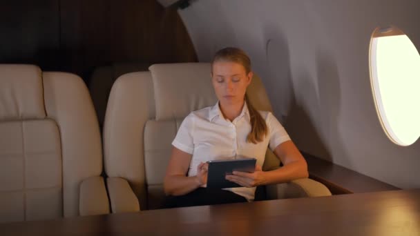 Zakenvrouw met Tablet PC binnenkant van Private Jet - Video