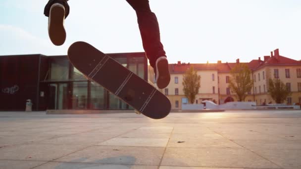 Zeitlupe, Nahaufnahme: Filmaufnahme eines männlichen Skaters, der an einem sonnigen Abend einen Fakie landet. Unerkennbarer Skateboarder springt in die Luft und landet bei schönem Sonnenaufgang einen coolen Trick auf seinem Board. - Filmmaterial, Video