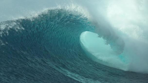 Pomalý pohyb, zblízka: Skleněné kapky mořské vody odletět od velkolepé trubkové vlny zřícení v blízkosti tropické pláže v Teahupoo, Tahiti. Perfektní hlaveň se láme a šplouchá do modré oblohy. - Záběry, video