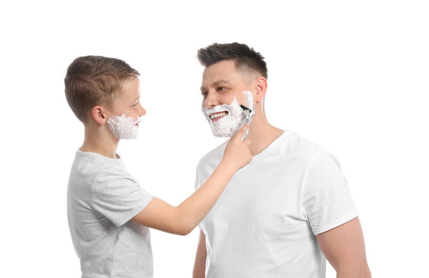 Son shaving his dad with razor isolated on white - 写真・画像
