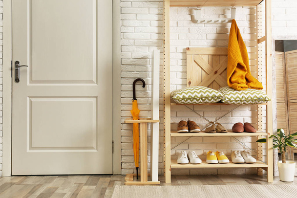 Cozy hallway interior with wooden shelving unit. Stylish design idea - Foto, Imagem