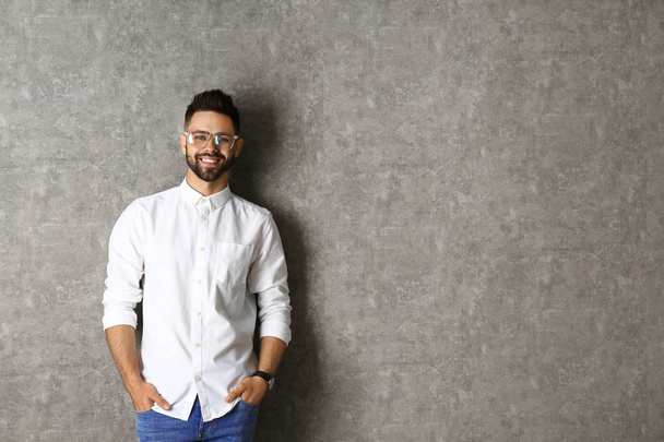 Portrait of handsome smiling man in glasses on grey background. Space for text - Photo, image