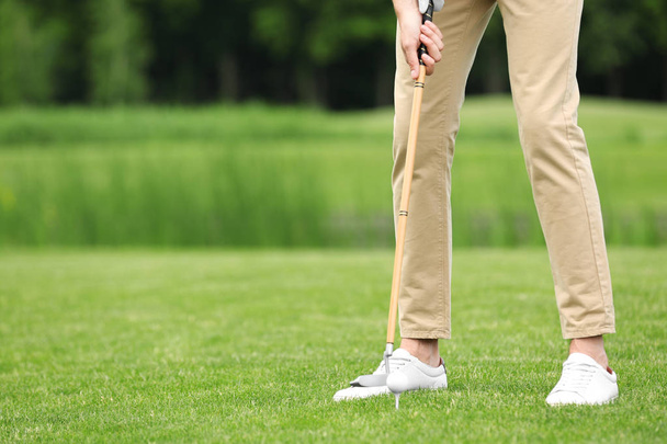 Человек, играющий в гольф на зеленом поле. Спорт и отдых
 - Фото, изображение