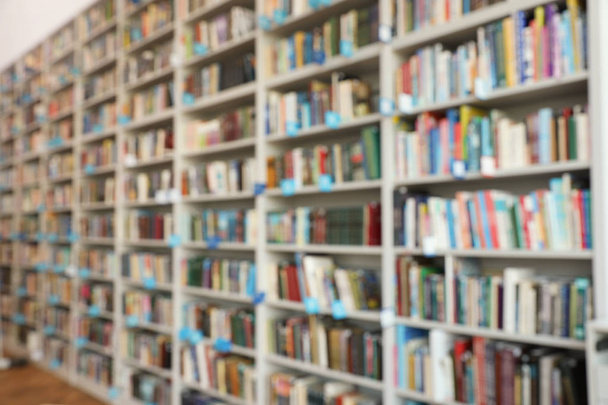 Blurred view of shelves with books in library - Photo, Image