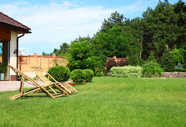 Wooden deck chairs in garden on sunny day - Photo, Image
