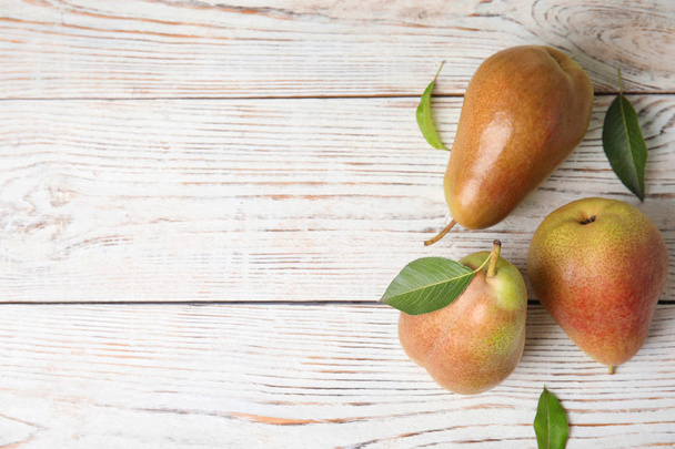 Ripe juicy pears on white wooden table, flat lay. Space for text - Фото, изображение