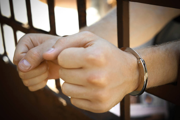屋外の刑務所で手錠をかけられた男、クローズアップ。刑法 - 写真・画像