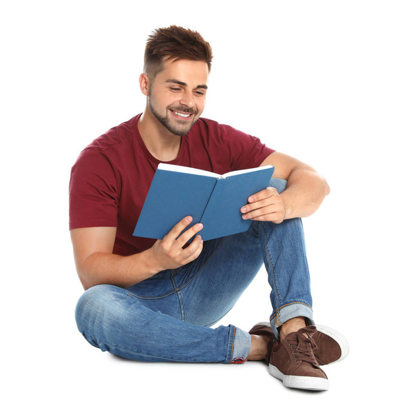 Handsome young man reading book on white background - Zdjęcie, obraz