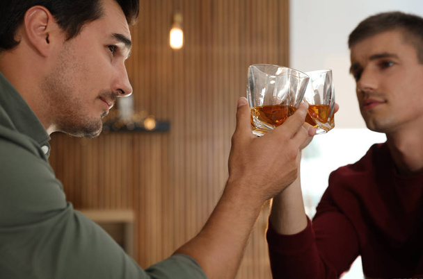 Young men drinking whiskey together in bar - Foto, Imagem