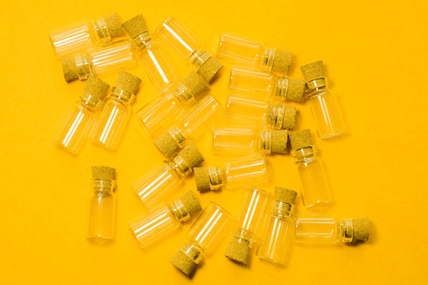 Empty little bottles with cork stopper isolated on yellow. transparent containers. test tubes - Foto, Imagem