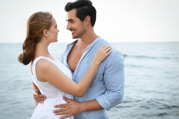 Happy young couple spending time at sea beach - Foto, imagen