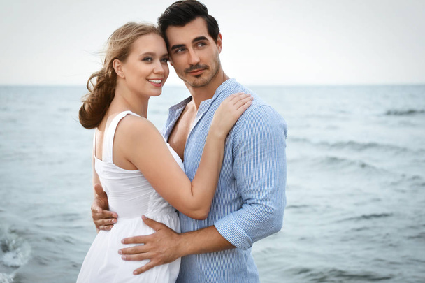 Happy young couple spending time at sea beach - Foto, imagen
