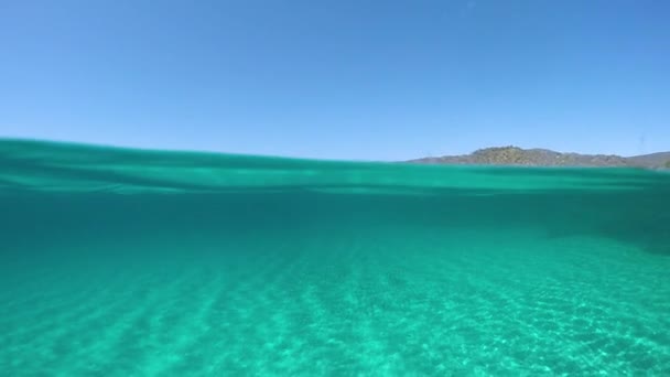 Slow Motion, Half Underwater: Γραφική θέα από τον γαλαζοπράσινο ωκεανό του μακρινού νησιού στην ηλιόλουστη Μεσόγειο. Κινηματογραφικό μισό της πεντακάθαρης θάλασσας και εκπληκτική Σαρδηνία σε μια ηλιόλουστη μέρα. - Πλάνα, βίντεο