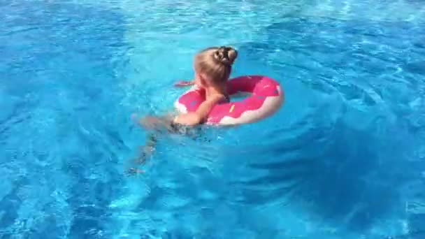 Kind in het zwembad. Een klein meisje is zwemmen in het zwembad. - Video