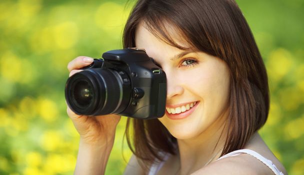 Imagen de una joven mujer hermosa fotografiando en el parque de verano
 - Foto, imagen