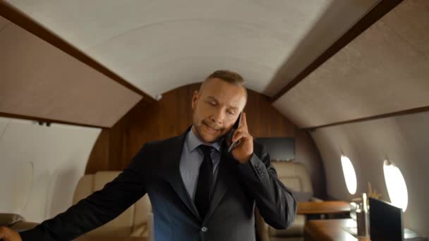 Businessman talking on mobile phone while travelling in private jet - Footage, Video
