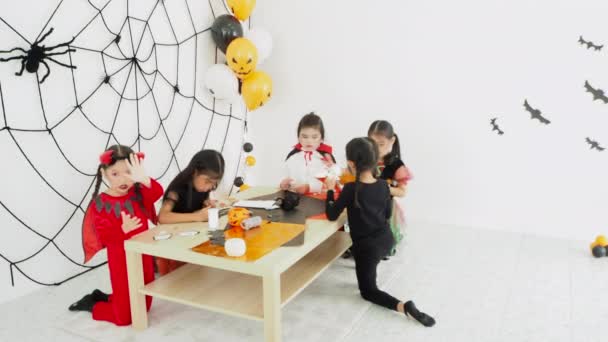 Gruppe kleines asiatisches Mädchen im Halloween-Kostüm feiert gemeinsam den Feiertag auf der Halloween-Party im Zimmer - Filmmaterial, Video