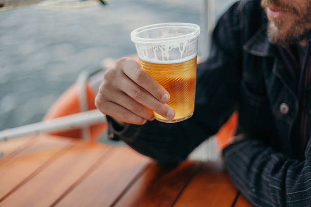 Man drinks beer on boat - 写真・画像