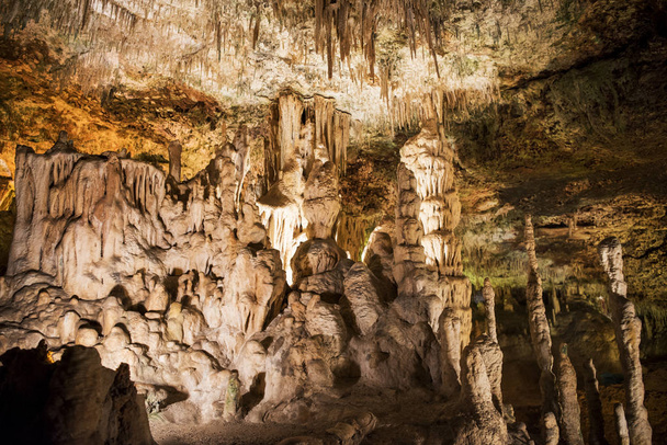 Cave dark interior with light, stalactites and stalagmites - Photo, Image